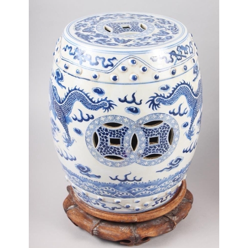 93 - A pair of Chinese blue and white miniature garden seats, decorated dragons and clouds, on hardwood s... 