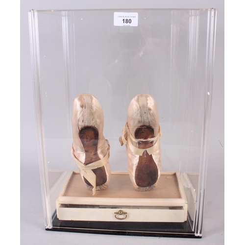 180 - A pair of peach ballet slippers worn by Dame Margo Fonteyn, signed in red ink verso, in Perspex disp... 