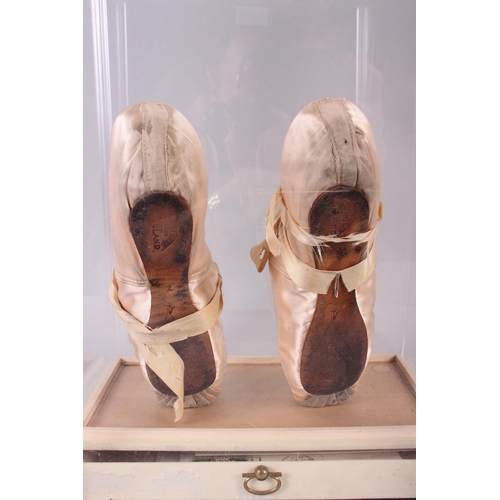 180 - A pair of peach ballet slippers worn by Dame Margo Fonteyn, signed in red ink verso, in Perspex disp... 