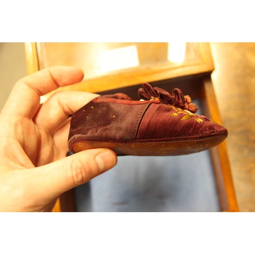 163 - An infant's pair of silk and embroidered shoes, in display case, 7 1/4