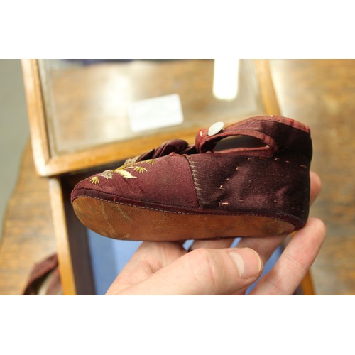 163 - An infant's pair of silk and embroidered shoes, in display case, 7 1/4