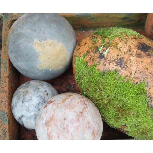 586 - Four hardstone balls, a hardstone finial, two terracotta egg-shaped ornaments, a white glazed plante... 