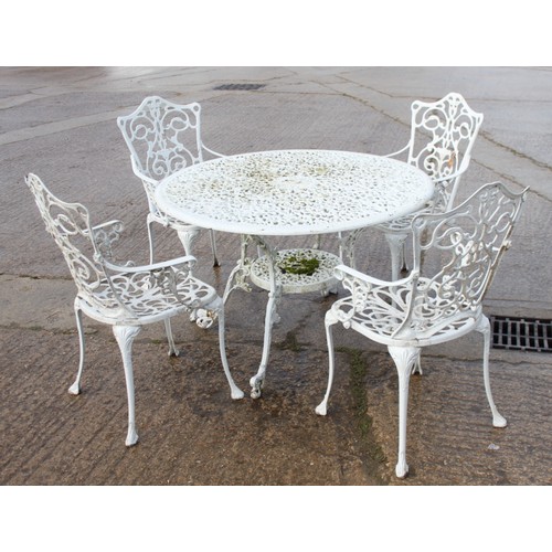 590 - A white painted aluminium circular openwork garden table and a set of four similar armchairs