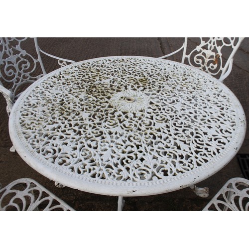 590 - A white painted aluminium circular openwork garden table and a set of four similar armchairs