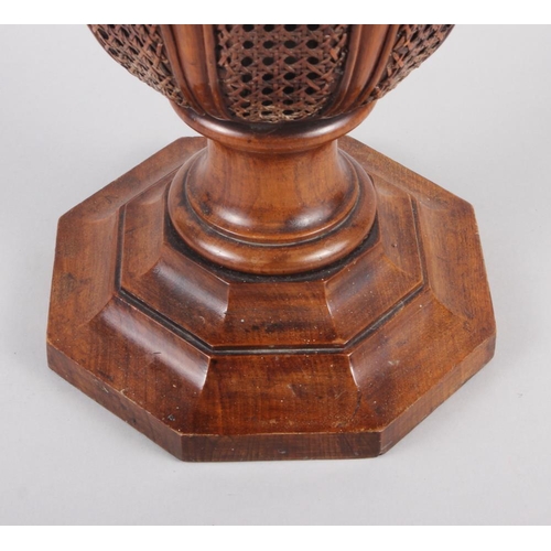 145 - A walnut and cane sided stick stand, on octagonal base, 17 3/4