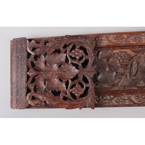 148 - An oak folding and extending book end with carved and pierced vine decoration, 16