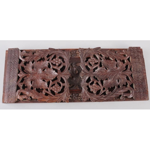 148 - An oak folding and extending book end with carved and pierced vine decoration, 16