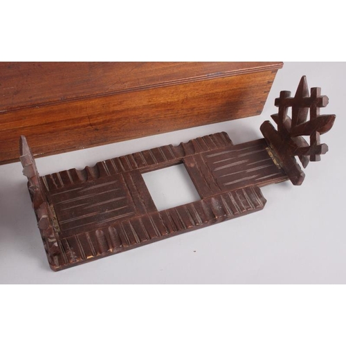 148 - An oak folding and extending book end with carved and pierced vine decoration, 16