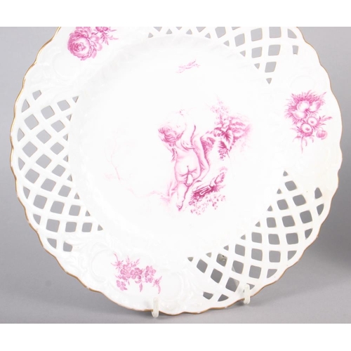 17 - A pair of bone china plates with puce cherub and floral decoration with pierced borders, 9 1/2