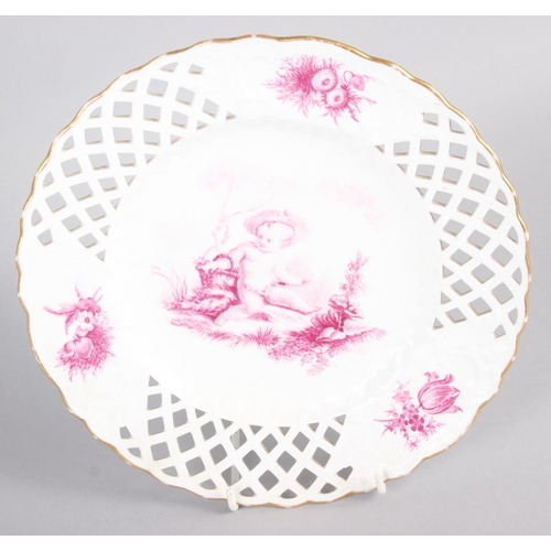 17 - A pair of bone china plates with puce cherub and floral decoration with pierced borders, 9 1/2