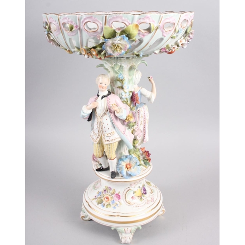 28 - A Continental porcelain table centre, the stem decorated with two figures and floral decoration to t... 