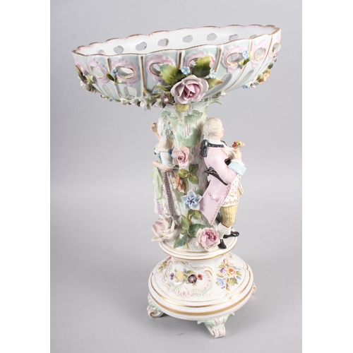 28 - A Continental porcelain table centre, the stem decorated with two figures and floral decoration to t... 