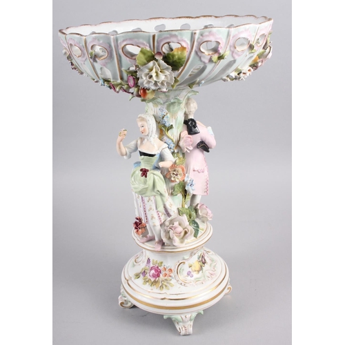 28 - A Continental porcelain table centre, the stem decorated with two figures and floral decoration to t... 