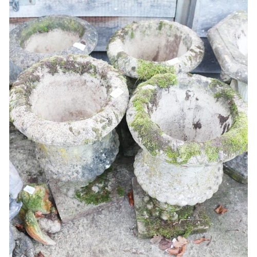 592 - A set of four cast stone campana urns, decorated fern leaves