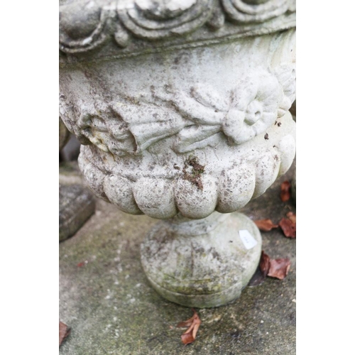 594 - A pair of stone pedestal planters, decorated flowers and swags, 18