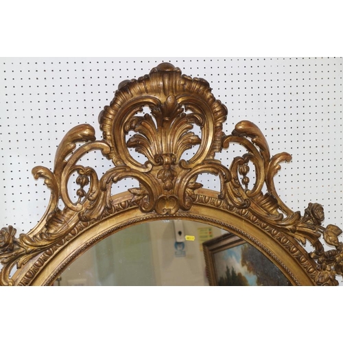 342 - A 19th century gilt framed oval wall mirror with Rococo scrolled and floral pediment and egg and dar... 