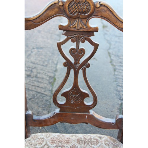 368 - A set of four carved walnut framed side chairs with pierced panel backs and stuffed over seats, on c... 