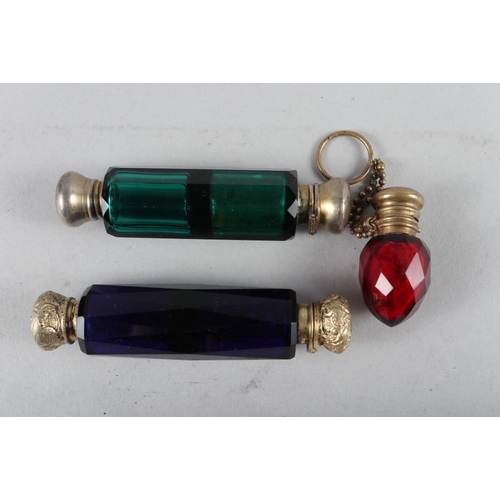 194 - A faceted blue glass double-ended scent bottle with gilt metal mounts, another similar green glass d... 