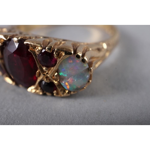 230 - An 18ct gold dress ring set central ruby and two opals