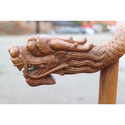 395 - A Chinese carved oak armchair with dragon head terminals and panel seat, 27