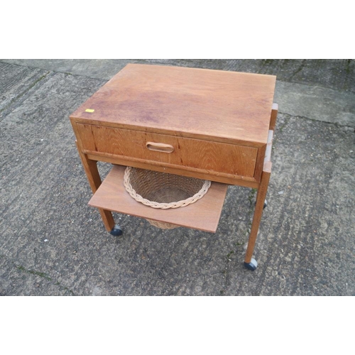 412 - An oak sewing table, on stretchered and castored supports, 22