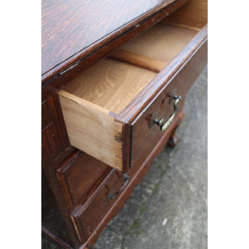 413 - An oak bureau with three graduated drawers, on claw and ball supports, 28 1/2