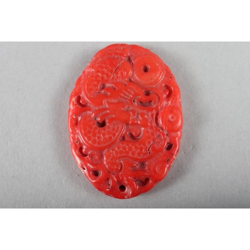 79 - A Chinese carved coral dragon pendant, a beaded coral necklace, total length 18 1/2