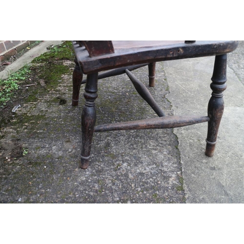 425 - A farmhouse lath back elbow chair with panel seat, on turned and stretchered supports