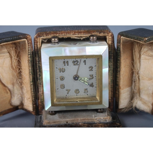 137 - An early 20th century abalone cased desk clock with gilt Arabic numerals, in leather case, 3