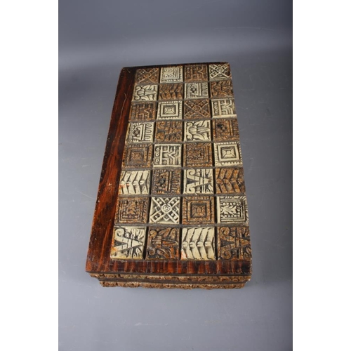 255 - An Aztec inspired composite chess set, in folding oak case