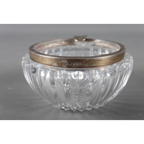 313 - A cut glass circular ashtray with silver rim