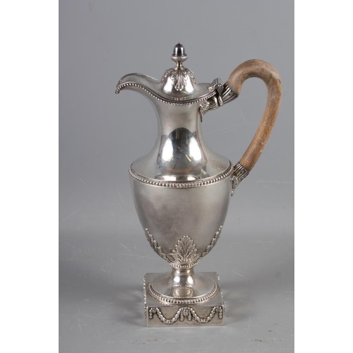 322 - An 18th century silver pedestal hot water jug with acorn finial, acanthus and laurel leaf decoration... 