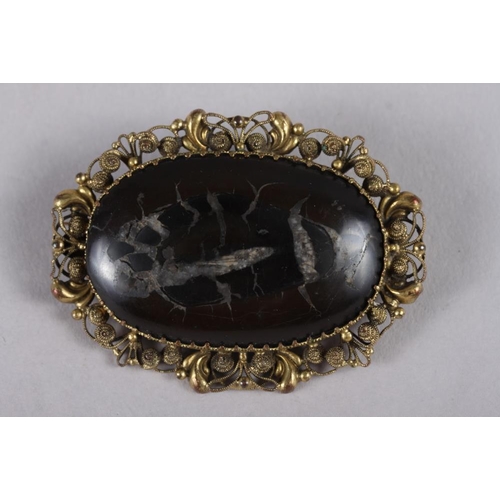 329 - A section of fossil, set into a yellow metal brooch mount, and a simulated pearl three-strand neckla... 