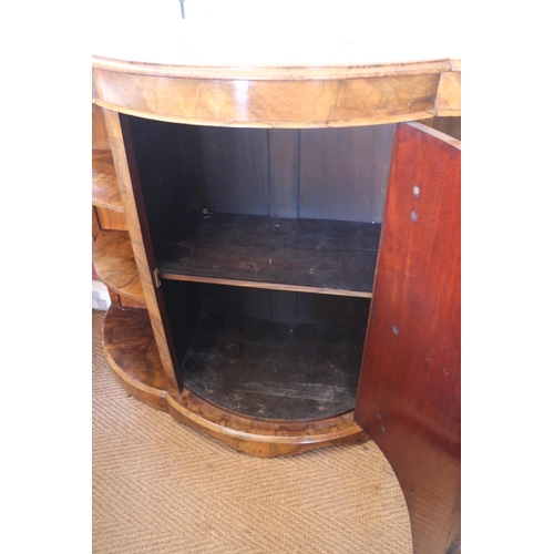 427 - A late Victorian figured walnut shape front credenza with open shelves and panel bowfront door, on b... 