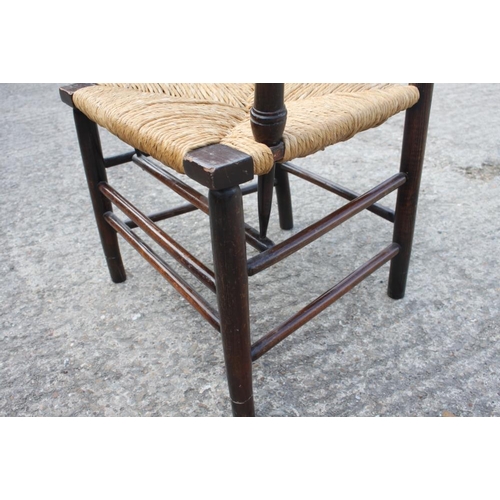 462 - A late 19th century Sussex elbow chair with rush envelope seat, on turned and stretchered supports