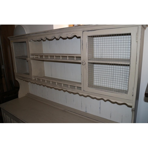 598 - A cream painted oak dresser, the upper section with galleried shelves and cupboards enclosed wire gr... 