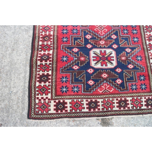 609 - A Turkman rug with starburst design on a washed red ground, 76