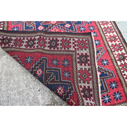 609 - A Turkman rug with starburst design on a washed red ground, 76