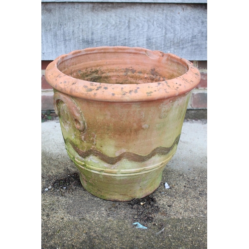 627 - A terracotta plant pot with undulated decoration and relief handles, 13 3/4