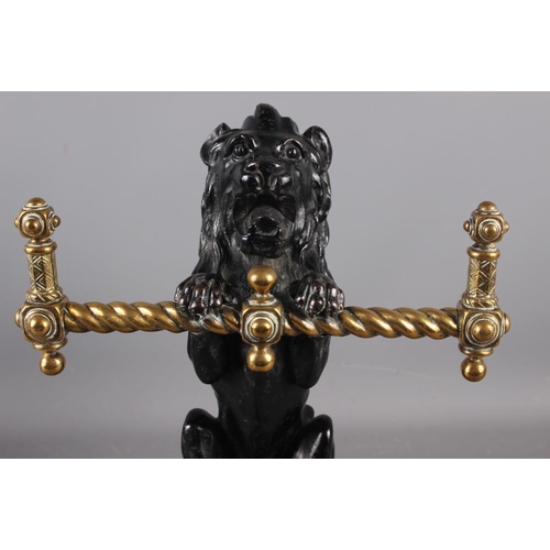 158 - A pair of mid 19th century cast iron and brass lion implement rests/fire dogs, 14