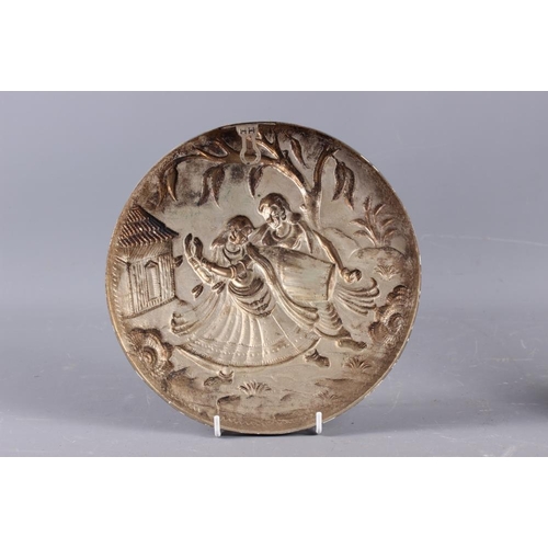 285 - An Indian embossed circular panel with dancer and musician, 8 1/2