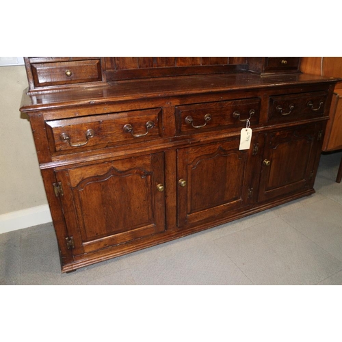 413 - An oak dresser, the upper section fitted two open shelves, two cupboards and two drawers, over three... 