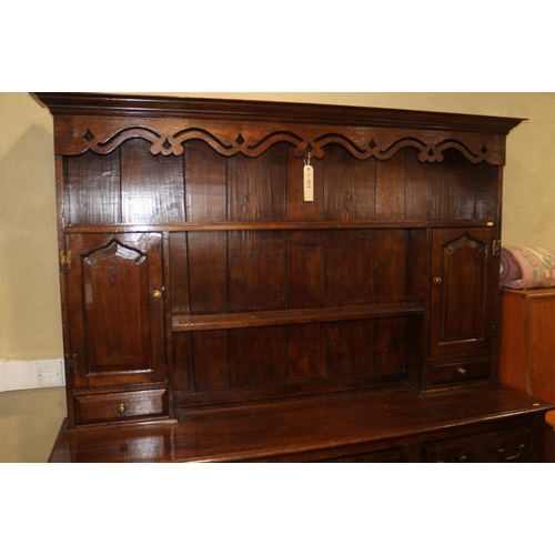 413 - An oak dresser, the upper section fitted two open shelves, two cupboards and two drawers, over three... 