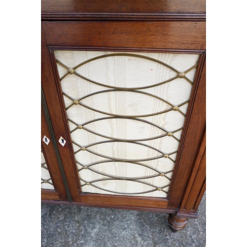 417 - A Regency mahogany chiffonier, fitted two open shelves over fabric fronted cupboards, on turned supp... 