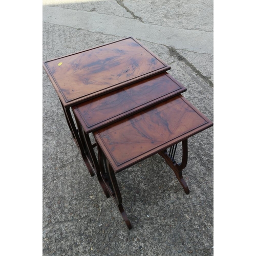 534 - A nest of three rectangular quarter veneered yew wood occasional tables, on lyre end supports, large... 