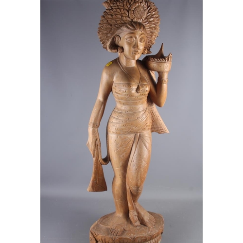 119 - An Indonesian carved wooden figure of a female standing on a lotus flower, 41