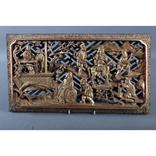 122 - A Chinese carved giltwood bed panel of a landscape with figures, 16 3/4