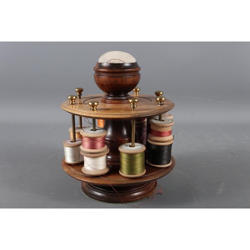 223 - A mahogany revolving bobbin stand with pin cushion, 7 1/2