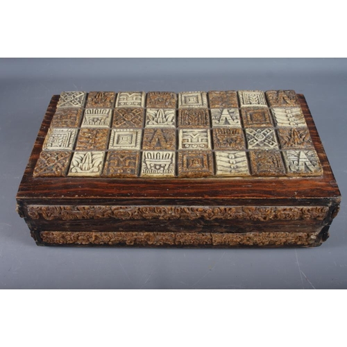 255 - An Aztec inspired composite chess set, in folding oak case