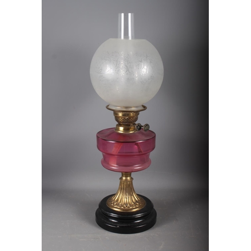 267 - A cranberry glass oil lamp with etched shade, 23 1/2